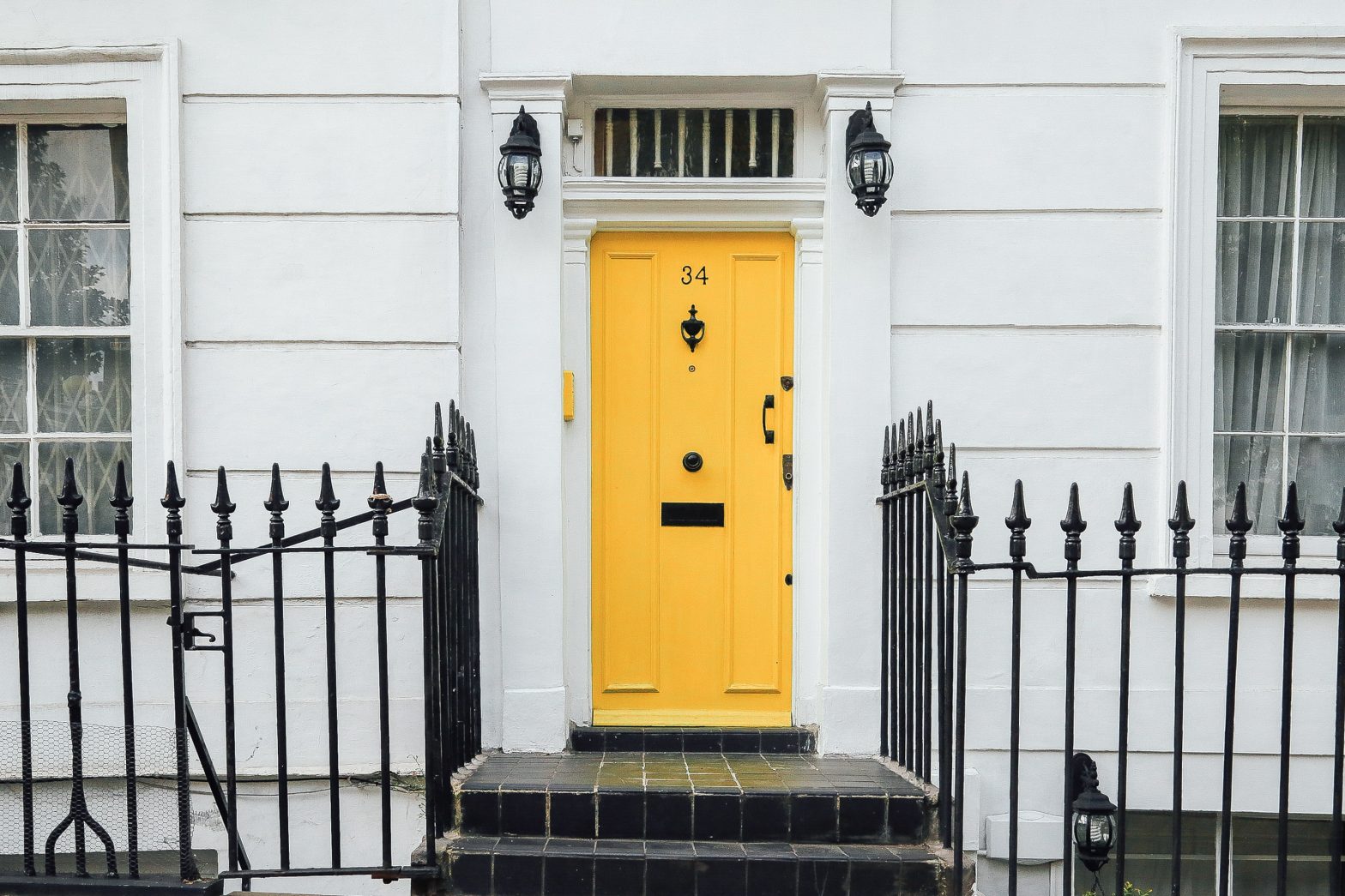 A white house with a bright yellow door.