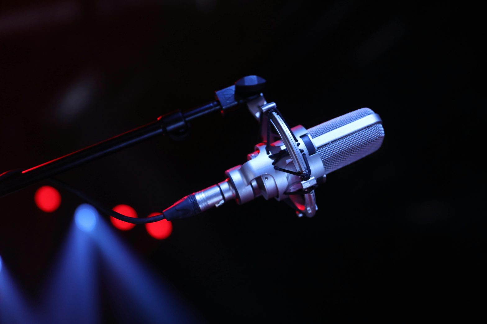 A professional microphone stands on a dark stage, symbolizing the high-stakes stand-up comedy set for a cancer fundraiser.