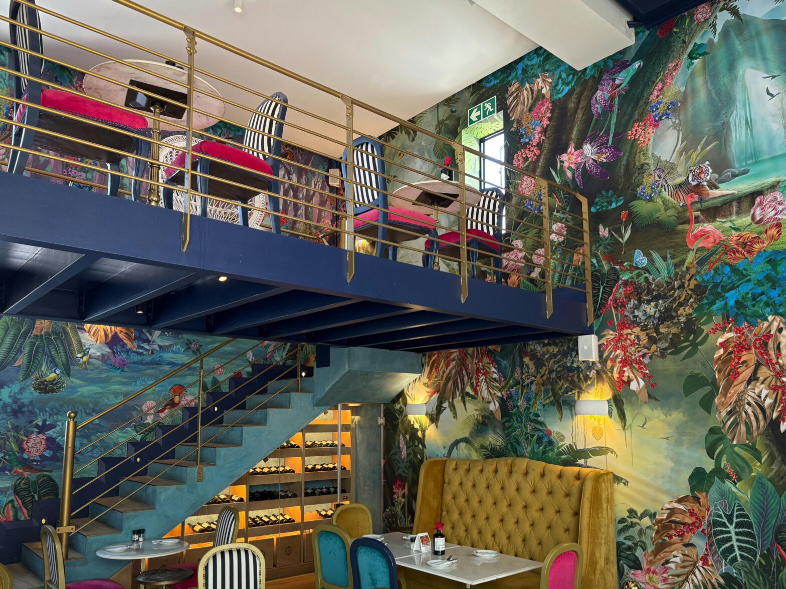 A vibrant interior space featuring curved orange velvet banquette seating, intricate geometric wood-slat wall and ceiling treatments, and warm atmospheric lighting that showcases the 2026 trend of "Warm Maximalism."