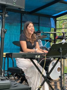 Hannah Manierka sings at a piano outside.