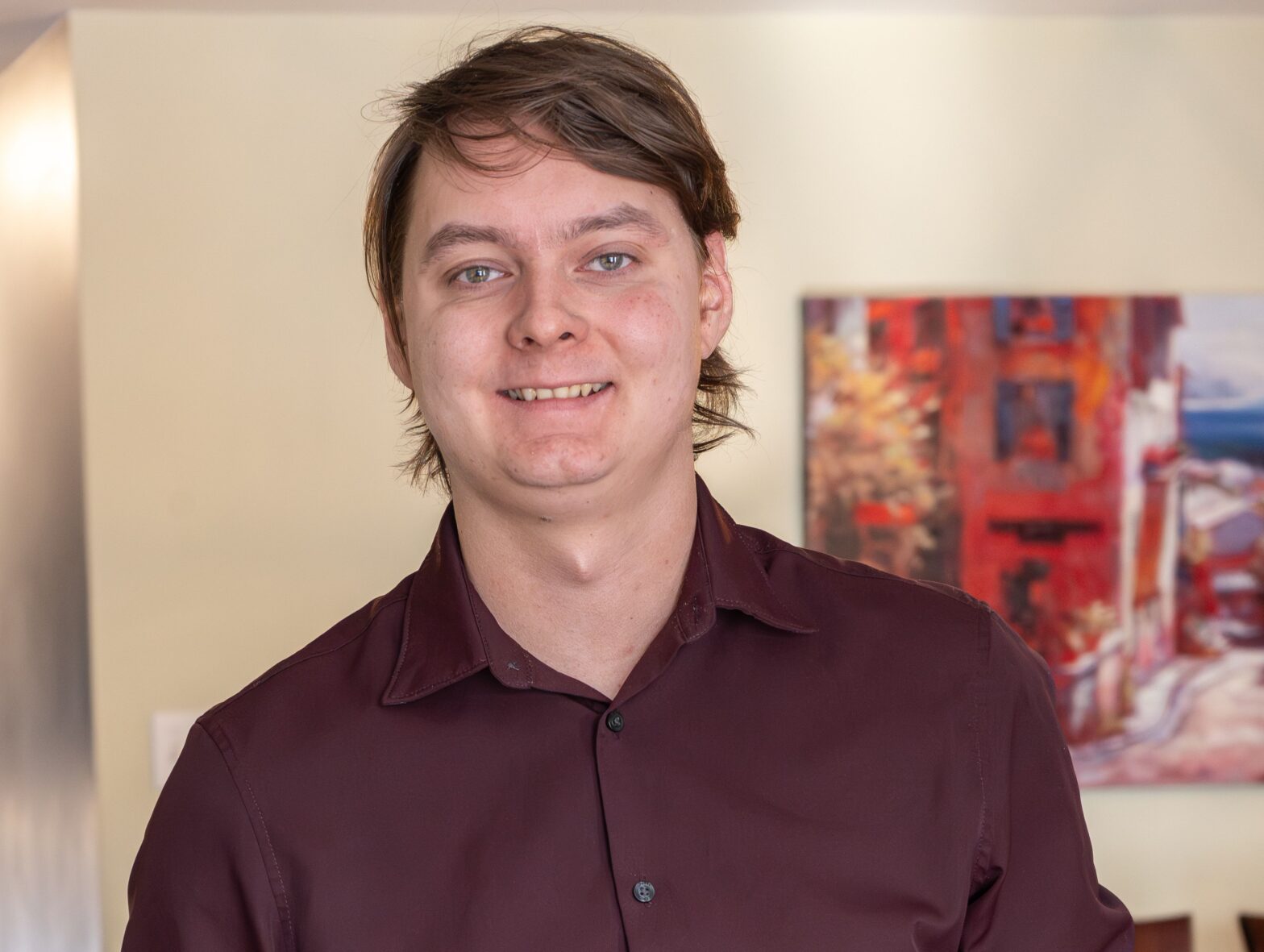 Headshot of Keegan Downs standing with hands in pockets in a burgundy button up shirt. Team Nick Fundytus.